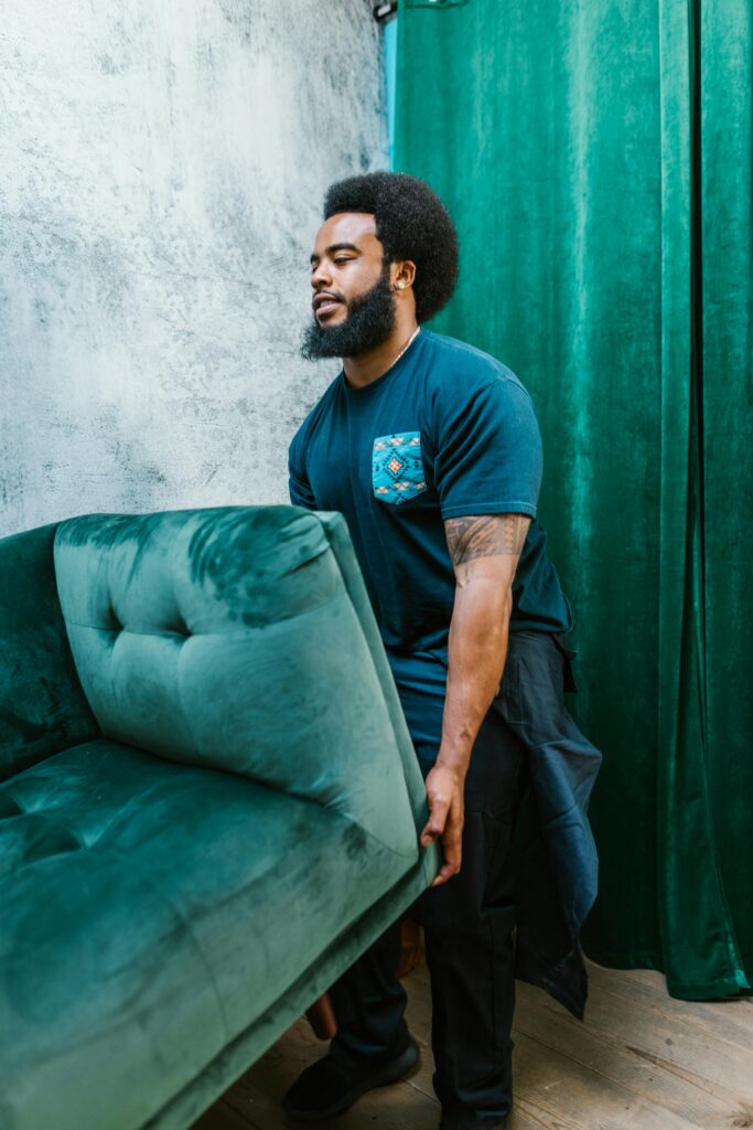 pexels-photo-7464691-7464691 A Bearded Man Carrying a Green Couch